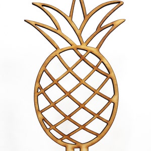 May include: A wooden cutout of a pineapple with a detailed design. The pineapple has a brown color and is on a white background.