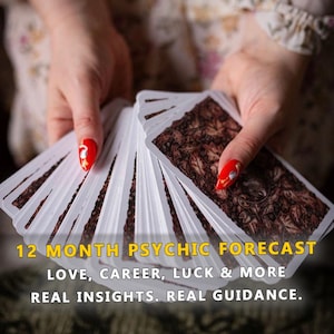 Puede incluir: Un mazo de cartas del tarot abanicado, sostenido por manos con esmalte de uñas rojo. Las cartas tienen un diseño marrón y blanco en el reverso. El texto en la parte inferior dice "12 MONTH PSYCHIC FORECAST, LOVE, CAREER, LUCK & MORE, REAL INSIGHTS. REAL GUIDANCE."