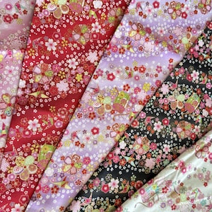 May include: A collection of colorful floral patterned fabrics. The fabrics feature a variety of colors, including pink, red, purple, black, and white. The floral patterns include cherry blossoms and other decorative elements.