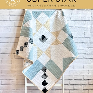 Puede incluir: Un patrón de acolchado para una colcha "Super Star". La colcha está compuesta por una gran estrella en el centro con estrellas más pequeñas en las esquinas. La colcha está en tonos de azul, blanco y amarillo. El patrón está disponible en tres tamaños: bebé (36" x 36"), regazo (48" x 48") y manta (60" x 60").