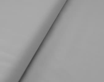 May include: A close-up of a smooth, light gray fabric. The fabric is folded in half, creating a diagonal line across the image.