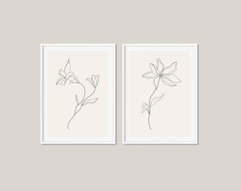 Puede incluir: Dos impresiones minimalistas de arte de línea de flores en marcos blancos. Las impresiones presentan dibujos simples de flores en línea negra con tallos y hojas delicados.