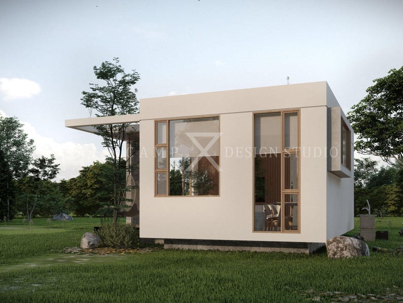 May include: A modern, white, minimalist building with large windows and a flat roof. The building is surrounded by green grass and trees. The text "AMP DESIGN STUDIO" is visible on the building.