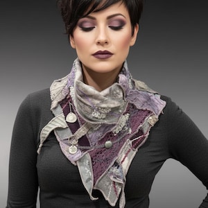 May include: A woman wearing a handcrafted, patchwork scarf in shades of purple, gray, and silver. The scarf features intricate textures, buttons, and decorative elements. The woman is wearing a dark gray long-sleeve shirt.