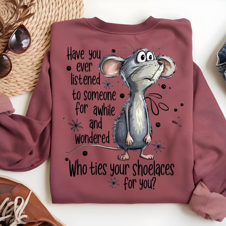 May include: A maroon sweatshirt featuring a cartoon mouse with the text "Have you ever listened to someone for awhile and wondered Who ties your shoelaces for you?" The mouse is gray and white with large ears and is looking upwards.