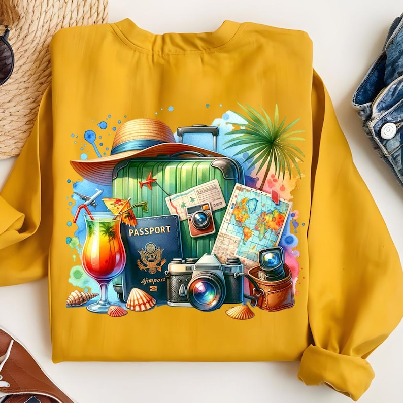 Puede incluir: Sudadera amarilla mostaza con una ilustraci&oacute;n de acuarela de elementos de viaje. El dise&ntilde;o incluye una maleta, pasaporte, c&aacute;maras, un c&oacute;ctel, un mapa, un sombrero y conchas marinas, evocando un tema de vacaciones.