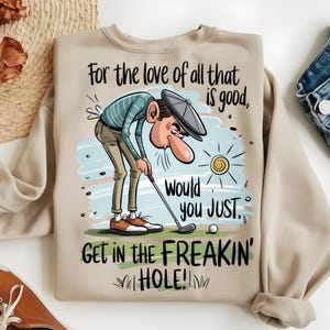 Puede incluir: Sudadera beige con un dise&ntilde;o tem&aacute;tico de golf. La ilustraci&oacute;n muestra a un golfista con el texto "For the love of all that is good, would you JUST, GET IN THE FREAKIN' HOLE!". El dise&ntilde;o incluye un sol, una pelota de golf y hierba.