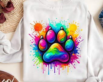 May include: White sweatshirt featuring a vibrant, colorful paw print design. The paw print is filled with rainbow hues and surrounded by paint splatters in shades of pink, blue, yellow, and green. A fun and playful design.
