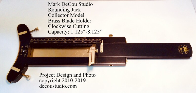 May include: A black wood rounding jack with a brass blade holder and a ruler marked in inches. The jack is labeled "Mark DeCou Studio" and "Rounding Jack Collector Model". The text "Capacity: 1.125"-8.125" is also visible.