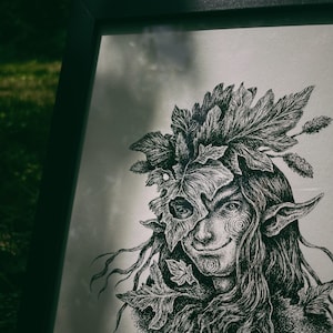 May include: A black and white ink drawing of a person with long hair and leaves covering their face. The person is wearing a leafy crown and has pointed ears. The drawing is framed in a black frame.