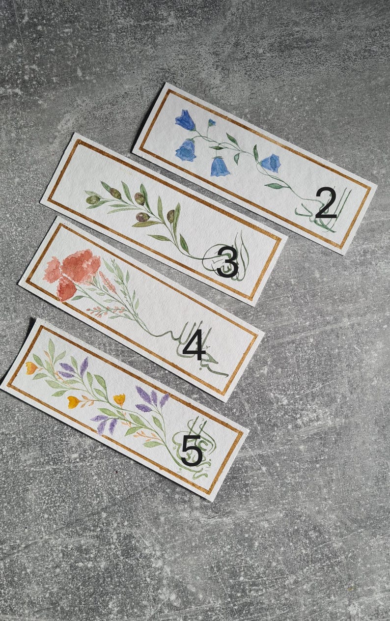 May include: Five watercolour bookmarks with gold trim and floral designs. Each bookmark has a number from 2 to 5 written on it.