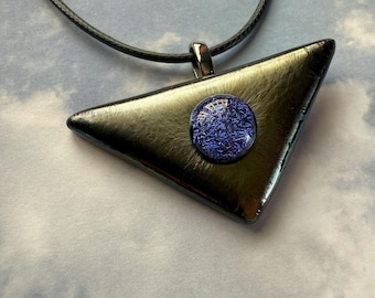 May include: A black cord necklace with a triangular pendant made of iridescent glass. The pendant has a round, blue glass cabochon in the center.