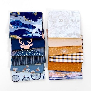 May include: A collection of folded fabric squares arranged in two vertical stacks. The left stack features navy, blue, and light blue patterns including abstract shapes, a deer silhouette, triangles, stripes, and tree rings. The right stack displays white, cream, mustard, and brown patterns featuring animal faces, geometric lines, sunbursts, plaid, and textured dots.