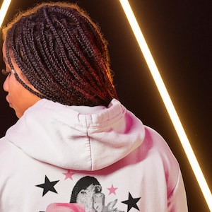 May include: A white hoodie with a pink and black graphic print featuring a woman's face, the text "Beabadoobee", and the text "Beatopia".