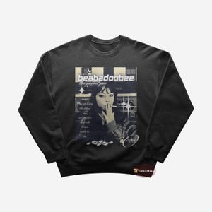 May include: Black sweatshirt featuring a graphic print of a woman smoking a cigarette. The graphic includes the text "beabadoobee the perfect pair".