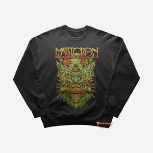 Puede incluir: Sudadera negra con un gráfico verde, rojo y amarillo de un monstruo con la palabra "MASTODON" encima.