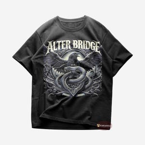 May include: Black t-shirt with a graphic print of a raven and snake with the text "Alter Bridge" in white.