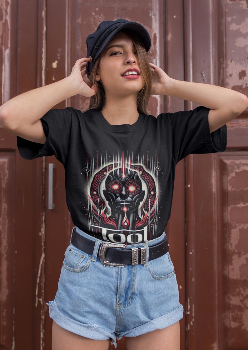 May include: A black t-shirt with a graphic of a red and black face with the word "TOOL" printed below it.