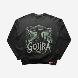 Puede incluir: Una sudadera gris oscuro con un gráfico verde de un árbol con raíces y la palabra "GOJIRA" en texto verde.
