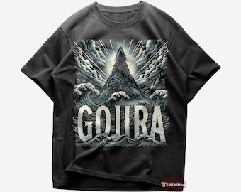 Può includere: Una maglietta nera con una stampa grafica di una montagna che sorge dalle onde dell'oceano. Il testo "GOJIRA" è stampato in bianco sotto la montagna.