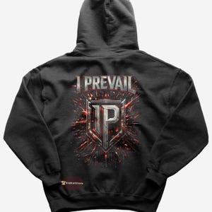 May include: Dark gray hoodie with the text "I PREVAIL" above a shield design with the letter "P" in the center. The design has red and white accents. The hoodie has a hood and a kangaroo pocket.