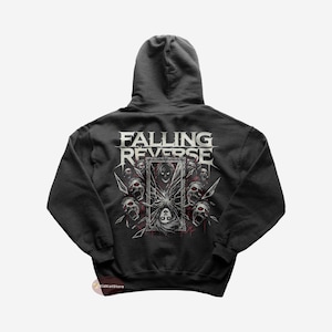 K&ouml;nnte beinhalten: Ein dunkelgrauer Kapuzenpullover mit dem Bandnamen "Falling Reverse" auf der R&uuml;ckseite. Das Design zeigt einen zerbrochenen Spiegel mit einem Frauenkopf darin und Sch&auml;deln, die ihn umgeben.