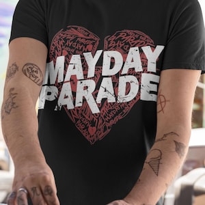 Pode incluir: Camiseta preta com um gráfico de coração vermelho que apresenta o texto "Mayday Parade" em branco. O coração é composto por repetições do nome da banda.