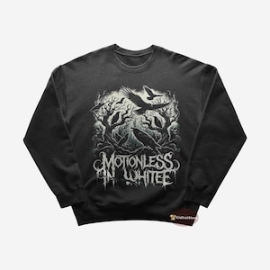 Może przedstawiać: Szara bluza z nadrukiem graficznym zespołu "Motionless In White". Grafika przedstawia leśną scenę z krukami i nazwą zespołu w gotyckiej czcionce.