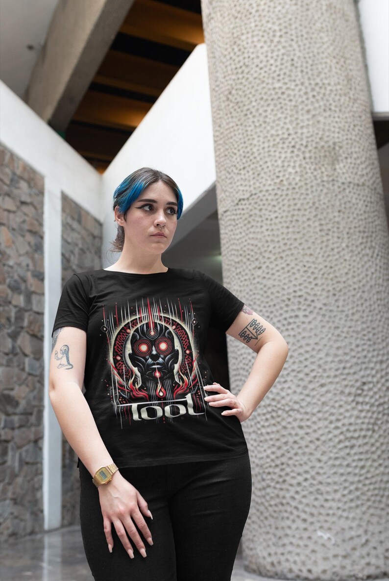 May include: A black t-shirt with a graphic print of a red and black robot head with the word "TOOL" printed below it.