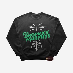 May include: A black sweatshirt featuring a green and white graphic of a radio tower with the text "The Dropkick Murphys".