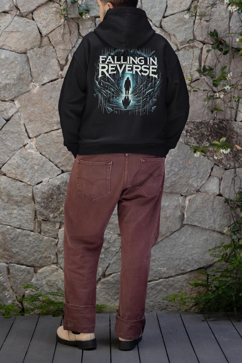 May include: Black hooded sweatshirt with a graphic print of a person standing in a dark, watery environment. The text "Falling in Reverse" is printed in white on the front of the sweatshirt.