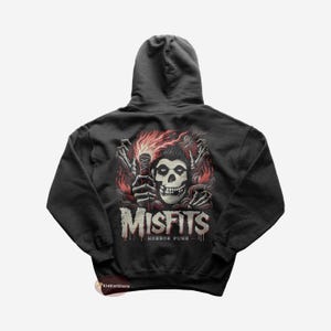 Może przedstawiać: Czarna bluza z kapturem z nadrukiem graficznym czaszki z płomieniami i tekstem "Misfits Horror Punk".