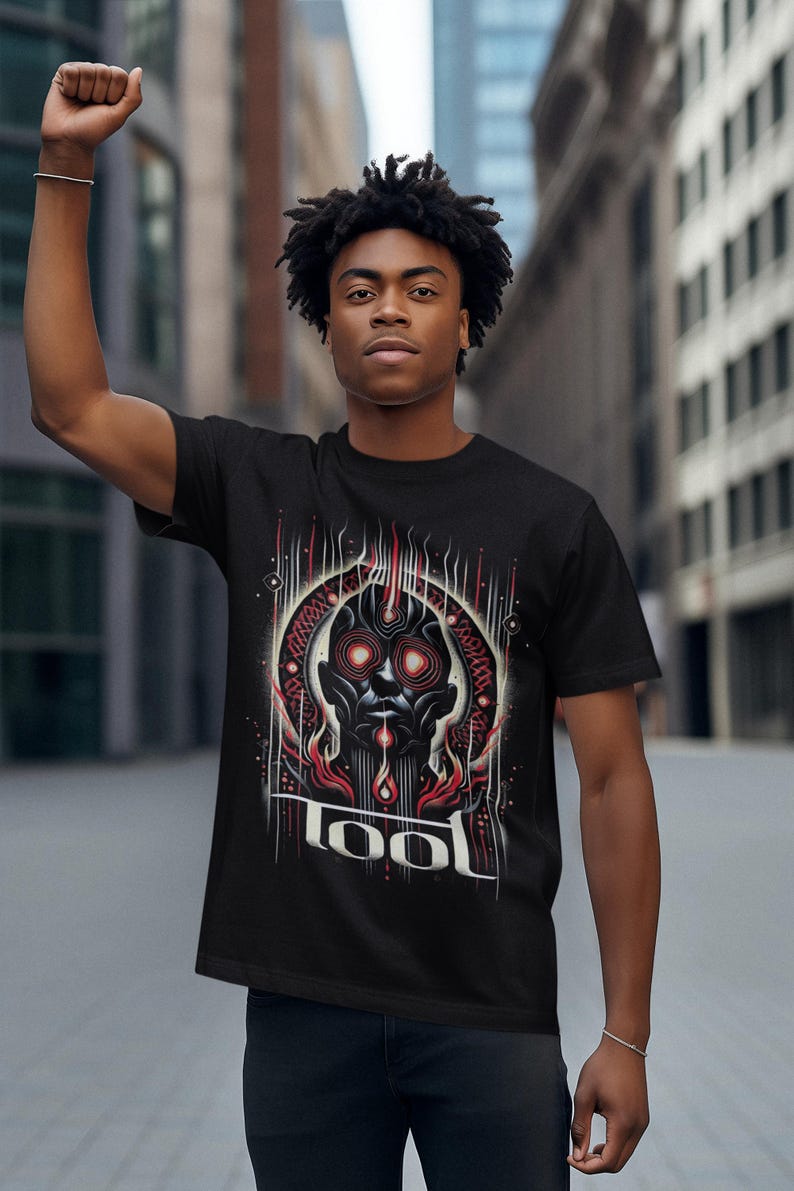 May include: A black t-shirt with a graphic print of a stylized face with red eyes and flames. The text "TOOL" is printed below the graphic.