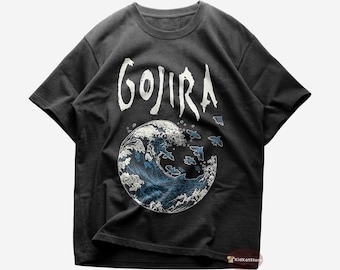Puede incluir: Camiseta negra con un gráfico blanco de una ola y la palabra "GOJIRA" impresa en ella.