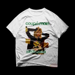 May include: White t-shirt featuring a green and white graphic print of a woman with long blonde hair. The graphic includes the text "coup de main" and "THE A-B-C'S OF BEABADOOBEE".