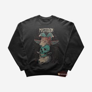 Puede incluir: Una sudadera negra con un estampado gráfico de una calavera, un lobo, un tigre y pájaros. El texto "MASTODON" está impreso sobre el gráfico.