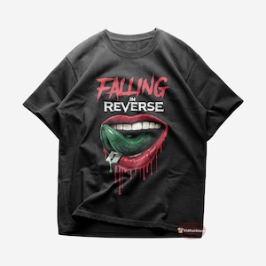 Könnte beinhalten: Schwarzes T-Shirt mit den Worten "FALLING IN REVERSE" in Rot und Weiß. Die Grafik zeigt einen Mund mit roten Lippen, einer grünen Zunge und einem Kaugummi. Rote Tropfen befinden sich unter dem Mund.