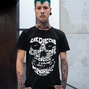 May include: A black t-shirt featuring a white skull graphic formed from the repeated word "die". The skull graphic also includes the words "my darling".