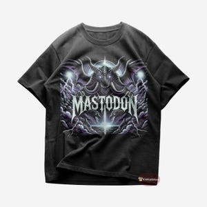 May include: Black t-shirt with a graphic of a purple and grey monster with wings and the text "MASTODON" in white.