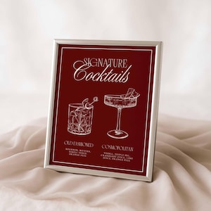 Puede incluir: Impresi&oacute;n enmarcada con fondo burdeos, texto blanco e ilustraciones. El texto dice "Signature Cocktails" encima de dos ilustraciones de c&oacute;cteles. Debajo, los nombres "Old Fashioned" y "Cosmopolitan" con sus ingredientes.