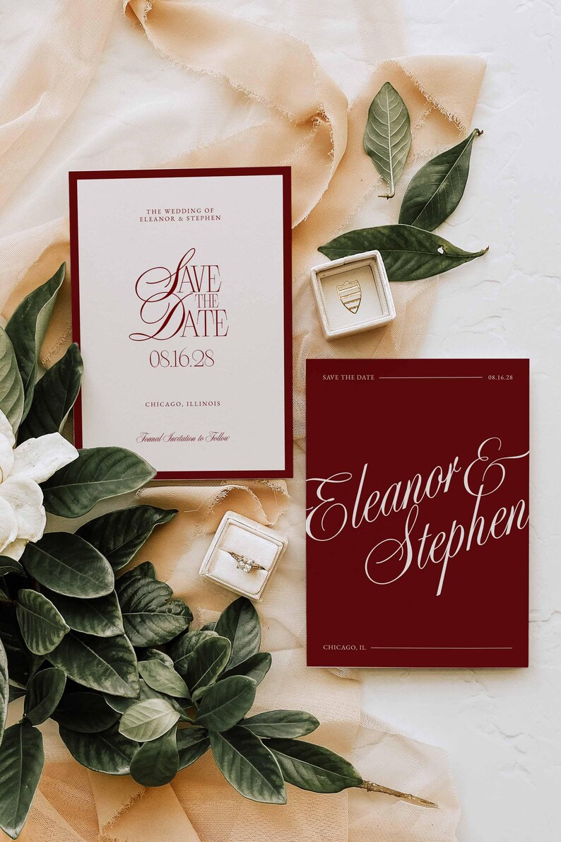 Op de afbeelding: Trouwuitnodigingsset met bordeauxrode en witte briefpapier. Het ontwerp omvat "Save the Date" kaarten met elegant schrift, de namen Eleanor & Stephen en de trouwdatum. Een ringdoosje en groen maken de opstelling compleet.