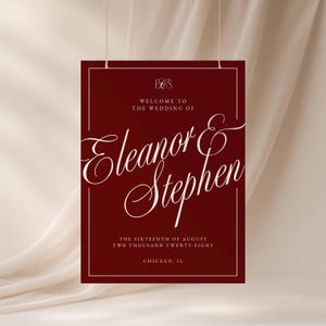 K&ouml;nnte beinhalten: Burgunderfarbenes Hochzeitsschild mit wei&szlig;em Text. Es lautet "Willkommen zur Hochzeit von Eleanor & Stephen". Das Datum ist der 16. August 2028, in Chicago, IL. Das Schild wird von einer wei&szlig;en Schnur gehalten.