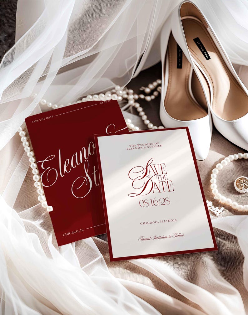 Op de afbeelding: Een trouwuitnodigingssuite met een bordeauxrode en witte kleurstelling. De kaarten lezen "Save the Date" met de namen Eleanor & Stephen en de datum 08.16.28. Witte hoge hakken en parelkettingen maken de elegante opstelling compleet.