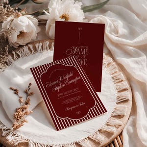 May include: Burgundy wedding invitation with white text and a striped border. The invitation includes the names Eleanor Westfield and Stephen Carrington, along with the date and time of the wedding. A second card with the words "IN THE NAME OF LOVE" is also visible.