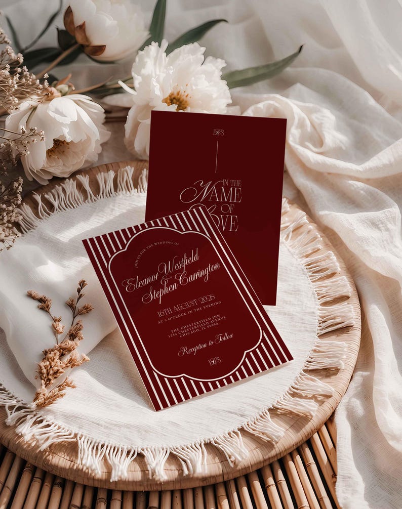 May include: Burgundy wedding invitation with white text and a striped border. The invitation includes the names Eleanor Westfield and Stephen Carrington, along with the date and time of the wedding. A second card with the words "IN THE NAME OF LOVE" is also visible.
