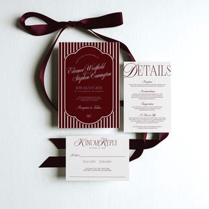 May include: Wedding invitation suite with burgundy and white design. The main invitation card features vertical stripes and elegant script. Additional cards include details and a reply card, all tied with a burgundy ribbon.