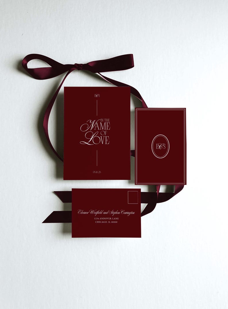 May include: Burgundy wedding invitation suite with a ribbon. The suite includes a card with "In the Name of Love" in elegant script, a card with initials, and an envelope with names and address. The date is 09.16.25.
