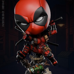 Può includere: Figura chibi di Deadpool rosso e nero in posa dinamica con due katane. La figura è su una base dettagliata con un contenitore verde e marrone con "BOOM". Modello in scala 1:6.