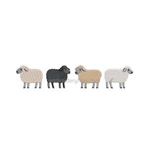 Könnte beinhalten: Vier gestickte Schafe in einer Reihe, jedes in einer anderen Farbe. Die Schafe sind beige, schwarz, hellbraun und weiß. Die Schafe stehen und blicken nach links. Das Bild befindet sich auf weißem Hintergrund.