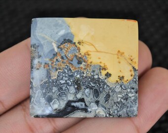 Puede incluir: Piedra cuadrada con un patrón único. La esquina superior derecha es de color amarillo claro, que pasa a gris y negro en la parte inferior. La piedra tiene un aspecto natural y terroso, con vetas y texturas intrincadas. Decorativo.